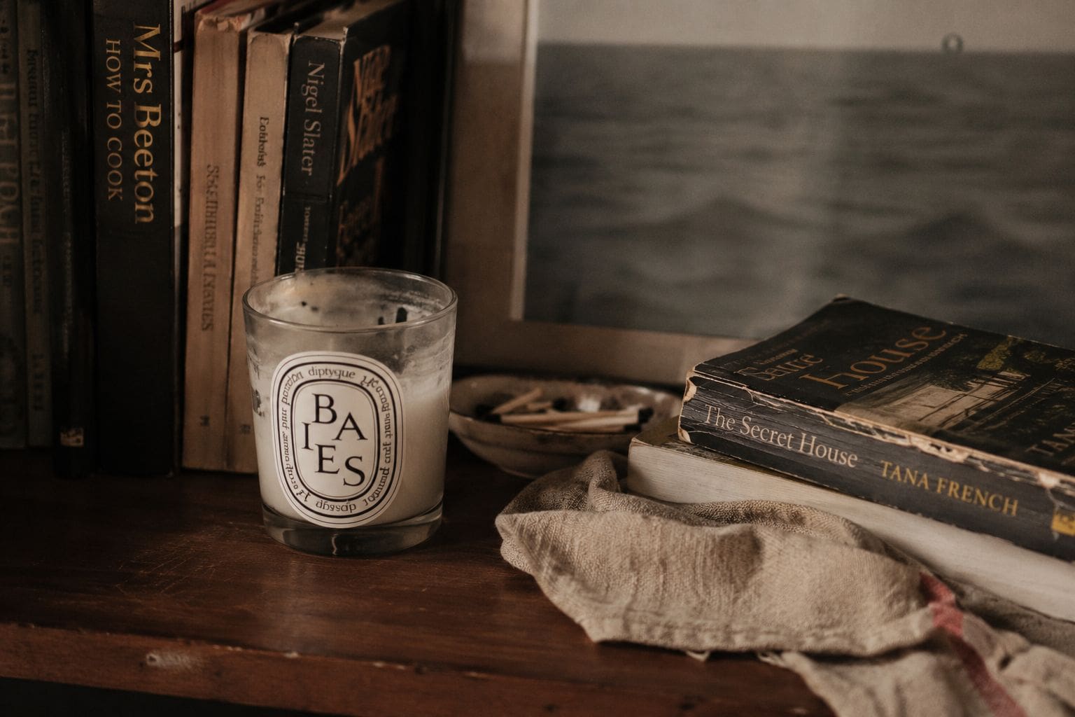 Lived-in shelf styled with layered objects illustrating the layered not staged principle